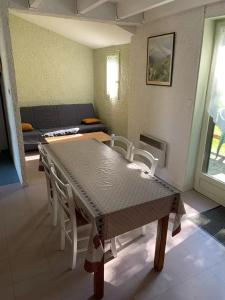 a dining table and chairs in a living room at ZEcamping 3 étoiles piscine animaux acceptés in Montaut