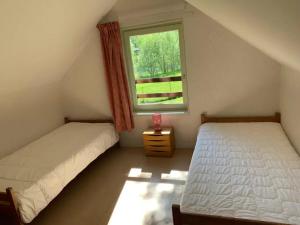 two beds in a room with a window at ZEcamping 3 étoiles piscine animaux acceptés in Montaut