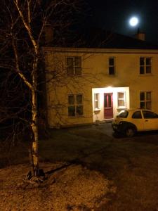 a white car parked in front of a house at night at B&B on Ballyneety Golf Course in Limerick