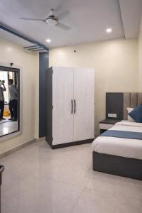 a bedroom with a bed and a cabinet and a mirror at The Nest Kashi in Varanasi