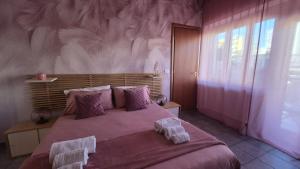 a bedroom with a large bed with a pink wall at CinqueStanze in Cosenza