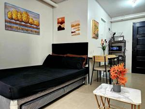 a bedroom with a bed and a table in a room at Cozy Plumera Studio near Mactan Airport in Bankal