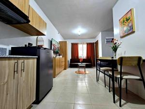 a kitchen with a refrigerator and a table and chairs at Cozy Plumera Studio near Mactan Airport in Bankal +5 photos