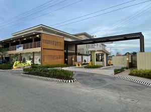a building with a parking lot in front of it at Cozy Plumera Studio near Mactan Airport in Bankal