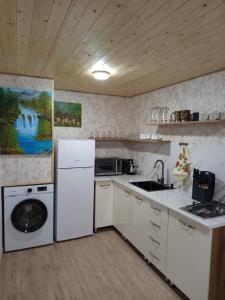 a kitchen with white appliances and a washer and dryer at Sno Valley Cottage in Sno