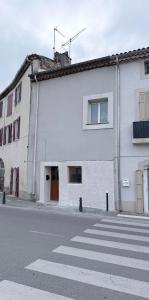 a white building on the side of a street at Le Petit Provençal in Sénas