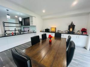 a room with a table and chairs and a kitchen at My Home II in Tarneit