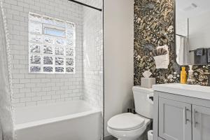 a bathroom with a toilet and a tub and a sink at Cozy 2BR Near Ohio State - Private Yard - Parking in Columbus