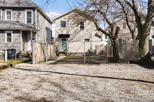 a house with a fence in front of a yard at Cozy 2BR Near Ohio State - Private Yard - Parking in Columbus +36 photos