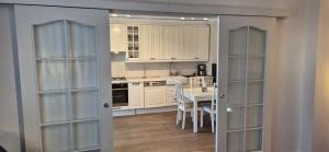 a kitchen with white cabinets and a table with chairs at Cosmo Iris in Ştefăneştii de Sus