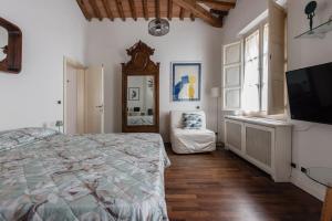 ein Schlafzimmer mit einem Bett, einem Spiegel und einem Fernseher in der Unterkunft Spacious 2BR Apartment for Families Central & Quiet Pisa in Pisa