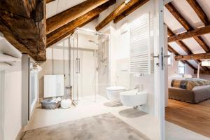a bathroom with a toilet and a glass shower at Stay COOPER l Laubenhaus in Bolzano