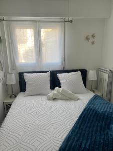 a white bed with two pillows and two windows at Gamiga in Menton
