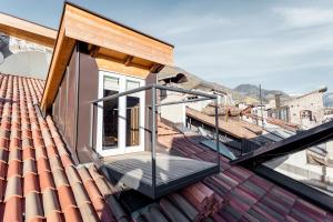 a balcony on a house with a dog on the roof at Stay COOPER l Laubenhaus in Bolzano