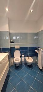 a blue tiled bathroom with a toilet and a sink at Gamiga in Menton +27 photos