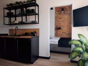 a kitchen with a sink and a bed in a room at LOFT Jana z Kolna in Koszalin