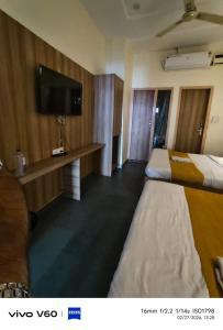 a hotel room with two beds and a flat screen tv at HR King HOTEL in Amritsar +11 photos