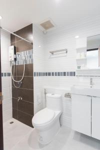 ein weißes Bad mit einem WC und einem Waschbecken in der Unterkunft Baan I Inspire in Phrae
