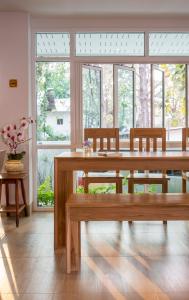 a dining room with a table and chairs and windows at Baan I Inspire in Phrae