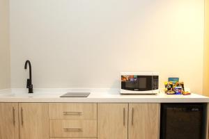 a kitchen counter with a microwave and a sink at Al Seef Hotel in Al-ʿUla