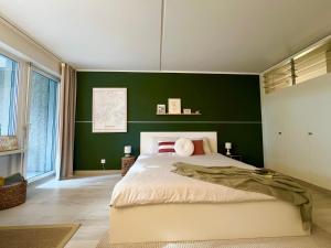 a bedroom with green walls and a large bed at Charming Suite am Luganersee, Pool, Parkplatz in Bissone
