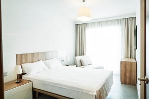ein Schlafzimmer mit einem großen weißen Bett und einem Fenster in der Unterkunft Luxury Apartment Las Terrazas in El Médano