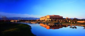a large building next to a river with a building at Hotel Peralada Wine Spa & Golf in Peralada
