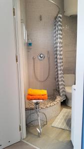 ポズナンにあるBlueGrayOrangeのバスルーム(シャワー、スツール上のオレンジタオル付)