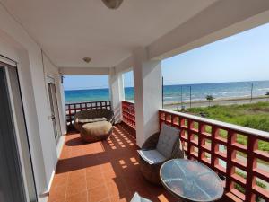 a balcony with chairs and a table and the ocean at First line houses in Sozopoli