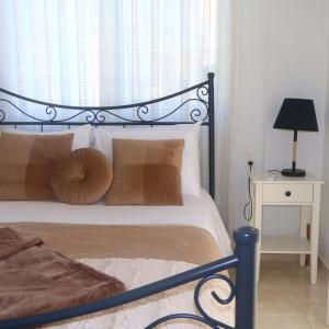 a bedroom with a bed with a black frame and pillows at Kýma Seafront House in Patra