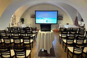 a room with a large screen in a room with chairs at Gasthof zum Goldenen Anker in Hainburg an der Donau