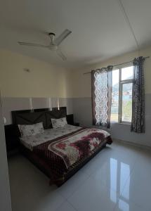 a bedroom with a bed and a window at Mahajan Lodge in Katra