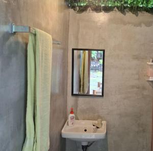 a bathroom with a sink and a mirror at Nipaville Haven in Moalboal +14 photos