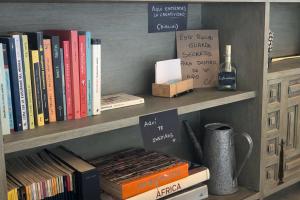 a book shelf with books and a bottle of wine at Apartamento Atalantar in Villanueva de la Vera