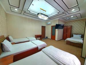 a room with two beds and a flat screen tv at DREAM PLAZA HOTEL for your convenience in Bukhara
