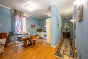 a living room with blue walls and a table and chairs at Appartamento San Giovanni - centro storico di Parma in Parma