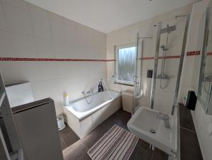 a bathroom with a tub and a sink and a shower at Alte Stadthauswohnung mit Flair in Celle +5 photos