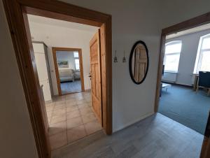 a hallway with a door and a mirror in a room at Alte Stadthauswohnung mit Flair in Celle