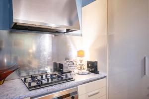a kitchen with a stove and a microwave at Appartamento San Giovanni - centro storico di Parma in Parma