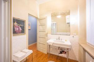 a white bathroom with a sink and a mirror at Appartamento San Giovanni - centro storico di Parma in Parma +15 photos