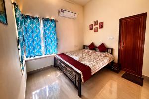 a bedroom with a bed with blue curtains at Swapno Chhobi in Bolpur