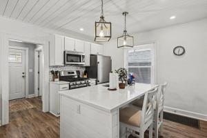 a kitchen with white cabinets and a white counter top at Luxe 2BR Franklinton - Private Patio - 2Car Garage in Columbus