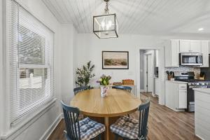 a kitchen and dining room with a wooden table and chairs at Luxe 2BR Franklinton - Private Patio - 2Car Garage in Columbus