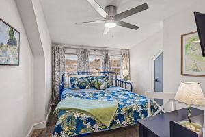 a bedroom with a blue bed and a ceiling fan at Luxe 2BR Franklinton - Private Patio - 2Car Garage in Columbus