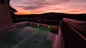 a hot tub on a balcony with a sunset at Hillside Cottage in Pécs +86 photos