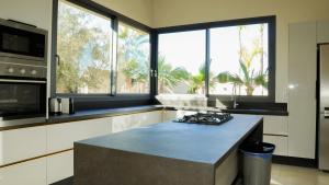 a kitchen with a island in a kitchen with windows at Villa Kaima Marrakech jacuzzi chauffé in Marrakesh