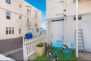 a balcony with blue chairs and a white fence at Manly Beach Studio in Sydney