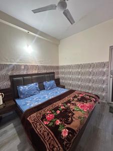 a bedroom with a bed with a blue comforter at Mahajan Lodge in Katra +2 photos