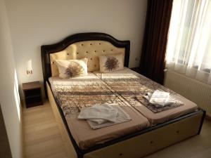 a bed with two towels on it in a bedroom at Къща за гости "Тони" in Dobrinishte