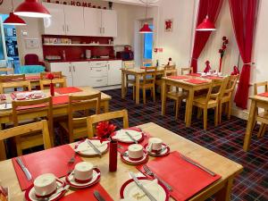 ein Esszimmer mit Holztischen und eine Küche in der Unterkunft Beeches Hotel in Blackpool